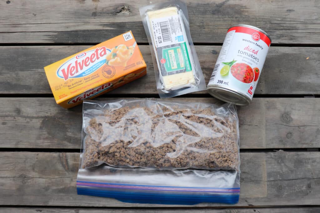 Rotel dip ingredients in packaging on a wooden table.