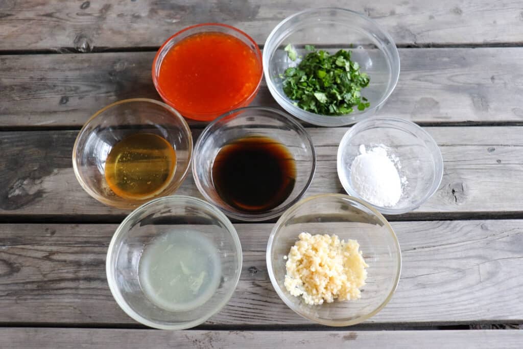 Ingredients for sweet chili chicken in clear glass bowls.