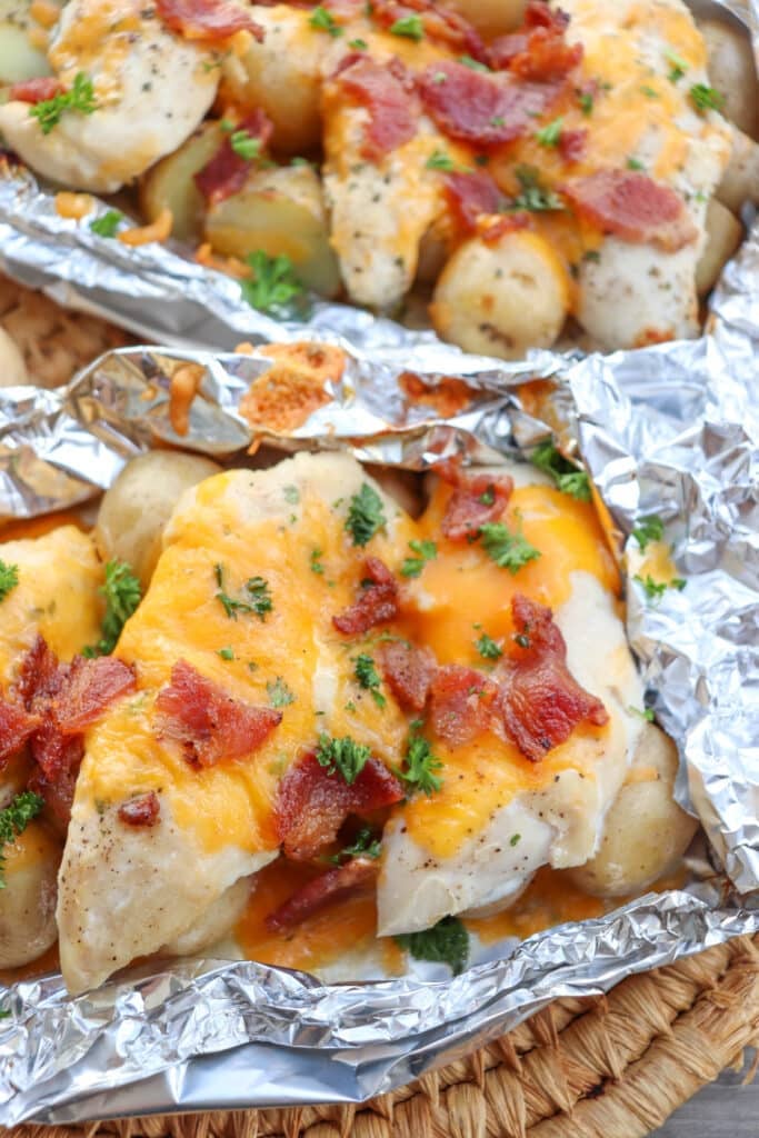 Close up of ranch chicken with melted cheddar cheese and bacon in a foil pack.