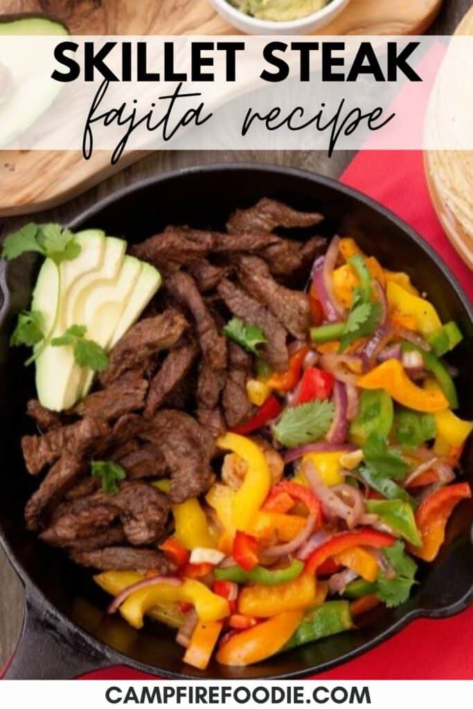 A skillet filled with cooked steak, colorful sliced bell peppers, and onion, garnished with avocado slices and cilantro. The text on the image reads, Skillet Steak Fajita Recipe and the website name Campfire Foodie.