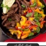 A cast iron skillet filled with sliced steak, colorful bell peppers, and red onions, garnished with cilantro and avocado slices. Text overlay reads Skillet Steak Fajita Recipe with the website name campfirefoodie.com below.