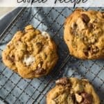 Four smores cookies with chocolate chunks and marshmallows on a cooling rack. The text Smores cookie recipe is at the top.