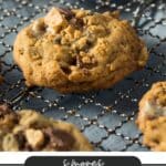 Close-up of homemade chocolate chip cookies with marshmallow bits on a cooling rack. The text below reads Smores Cookie Recipe from CAMPFIREEFOODIE.COM.