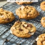 Freshly baked smores cookies with melted chocolate and marshmallows on a cooling rack. Text reads SMORES cookie recipe at the top and CAMPFIREEFOODIE.COM at the bottom.