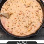 A skillet filled with cheesy beef dip, featuring melted cheese, ground beef, and diced tomatoes, is being stirred with a wooden spoon. The background includes a checkered cloth and a portion of bread. Text reads skillet cheesy beef dip and campfirefoodie.com.