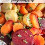 Colorful roasted vegetables, including beets, carrots, and potatoes, with herbs visible on top. They are placed on a piece of foil. The text reads Foil Packet Vegetables and campfirefoodie.com.