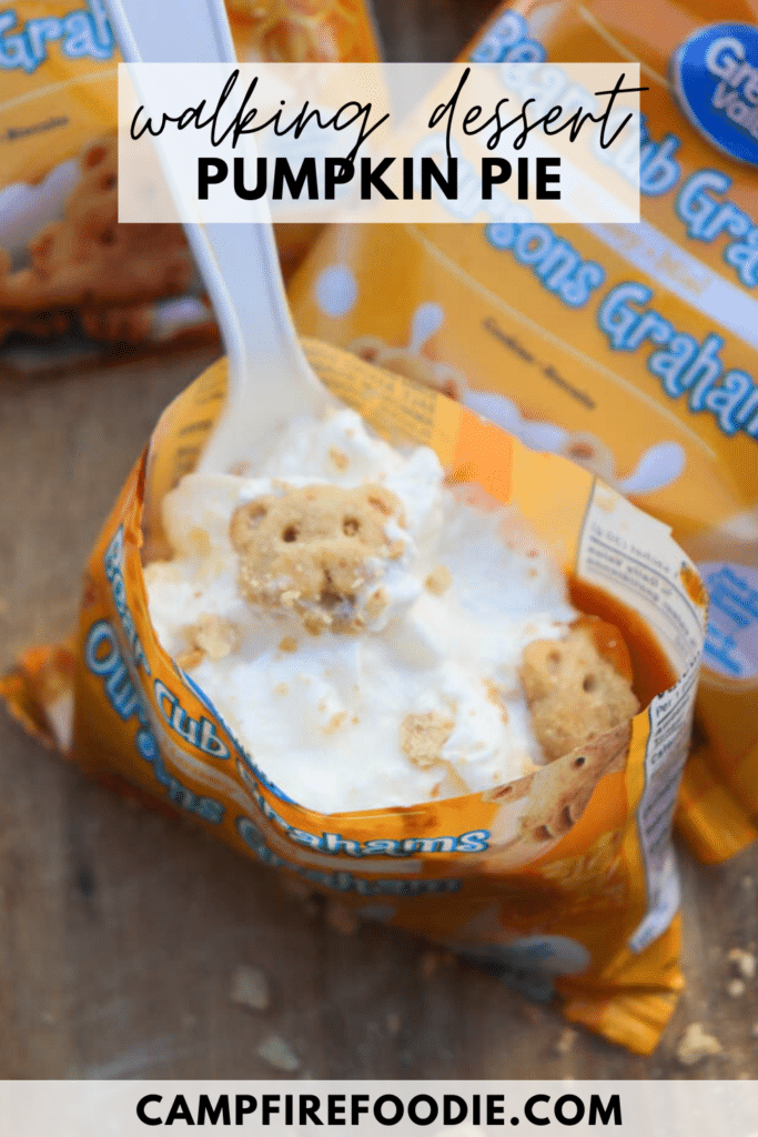 A snack-size bag of bear-shaped graham crackers is opened and filled with whipped cream and more crackers. A white plastic spoon is inside. Text on the image says walking dessert pumpkin pie and campfirefoodie.com.