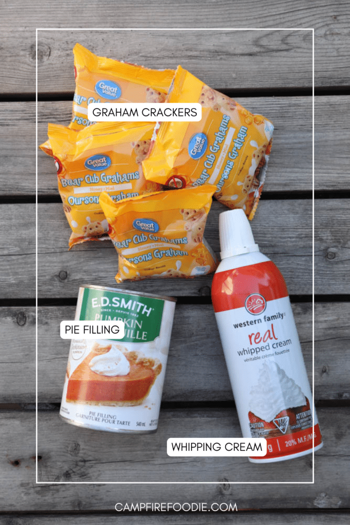 Four packs of Bear Club Grahams, a can of pumpkin pie filling, and a can of whipped cream are laid out on a wooden surface. Each item is labeled with white text.