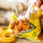 A close-up of a fork holding a cheesy chili dog mixture above an open bag of chips, with text reading Walking Recipe chili dogs and campfirefoodie.com on the image.