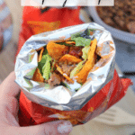 A hand holds an open snack-size Doritos bag filled with taco meat, lettuce, and salsa. Text reads Walking Tacos camping recipe and campfirefoodie.com appears at the bottom.