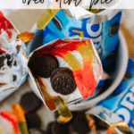 Open Oreo cookie packs filled with whipped cream, mini Oreos, and gummy worms on a table. Text over the image reads Walking oreo dirt pie and at the bottom, campfirefoodie.com.