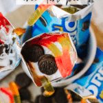 Overhead view of Oreo snack packs filled with whipped cream, mini Oreo cookies, and colorful gummy worms, labeled Walking Oreo Dirt Pie. The website campfirefoodie.com appears at the bottom.