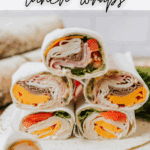 Six tortilla wraps filled with deli meat, cheddar cheese, lettuce, and tomato are stacked on a surface. Text above says Camping lunch wraps, and the website campfirefoodie.com appears at the bottom.