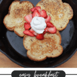 Three pieces of French toast in a skillet, topped with sliced strawberries and a dollop of whipped cream. Text below reads: Easy Breakfast French Toast Camping Hack campfirefoodie.com.