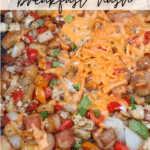 Close-up of a breakfast hash with diced potatoes, bell peppers, onions, scrambled eggs, and melted cheddar cheese on a Blackstone griddle. Text reads Blackstone breakfast hash and campfirefoodie.com.