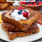 Three thick slices of French toast stacked on a plate, topped with whipped cream, blueberries, and raspberries. A bowl of mixed berries and orange slices are in the background. Text reads Blackstone French Toast.