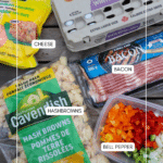 A photo displays packaged ingredients on a wooden surface: a carton of extra-large eggs, a bag of shredded cheese, sliced bacon, a bag of frozen hashbrowns, and a container of chopped bell peppers.