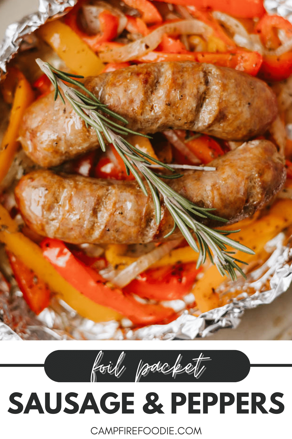 Two cooked sausages atop sliced red and yellow bell peppers with onions, garnished with a sprig of rosemary, all in a foil packet. Text reads: “Foil Packet Sausage & Peppers. campfirefoodie.com.”.