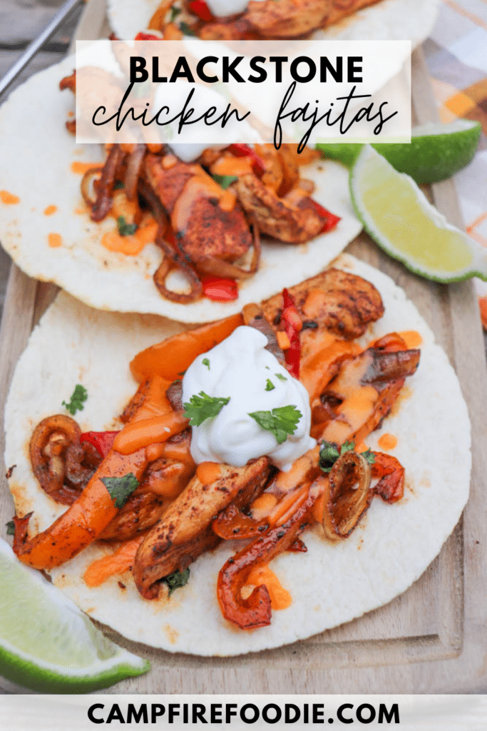 Two flour tortillas filled with seasoned grilled chicken, sautéed onions, and peppers, topped with sour cream, fresh cilantro, and a drizzle of orange sauce. Lime wedges are on the side. Text reads Blackstone Chicken Fajitas.
